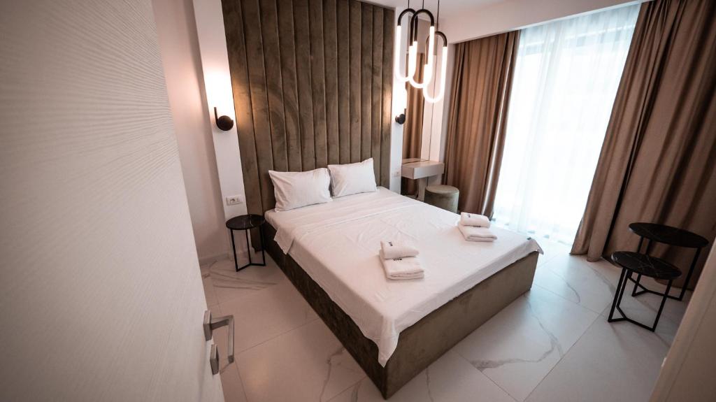 a bedroom with a bed with two towels on it at WAVE 4 Apartments Mamaia Nord in Năvodari