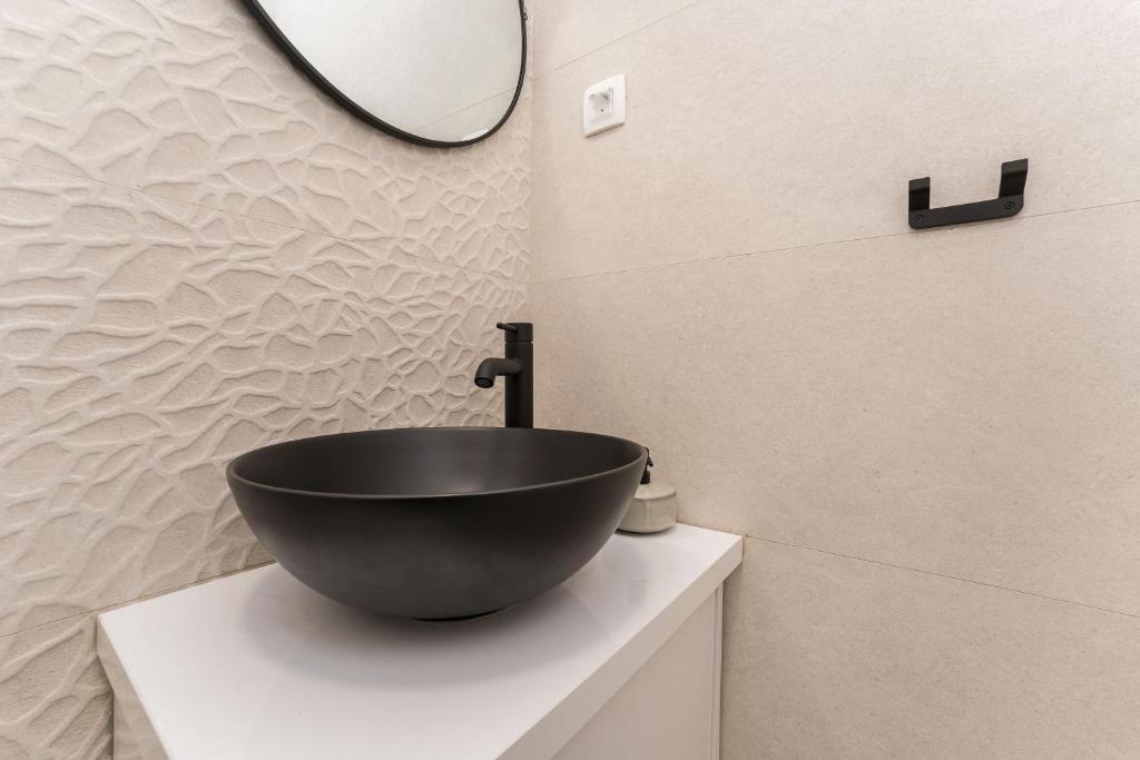 a bathroom with a black bowl sink on a counter at Luxury D Apartments in Bibinje