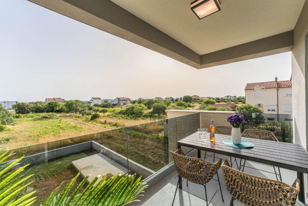 a patio with a table and chairs on a balcony at Luxury D Apartments in Bibinje