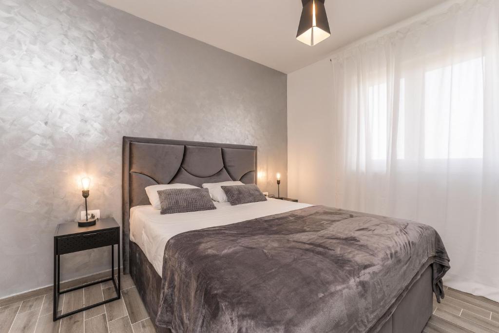 a bedroom with a large bed and a window at Luxury D Apartments in Bibinje