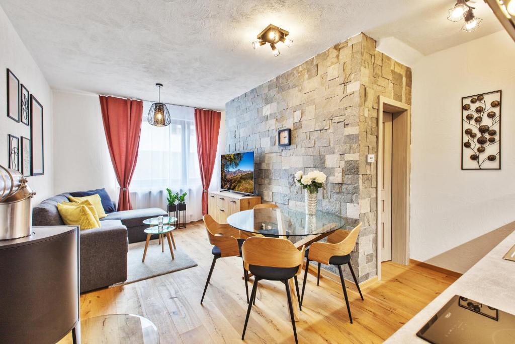 a living room with a glass table and chairs at Zaži Apartmány Mýto pod Ďumbierom in Mýto pod Ďumbierom