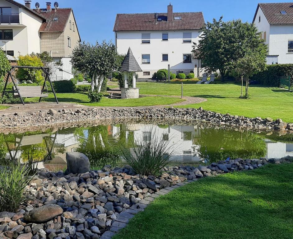 een vijver in het midden van een tuin met huizen bij Ferienwohnung Müller in Duderstadt