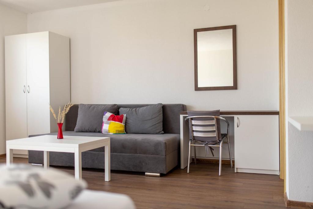 Sala de estar con sofá gris y mesa en Apartmani Mia en Prozor