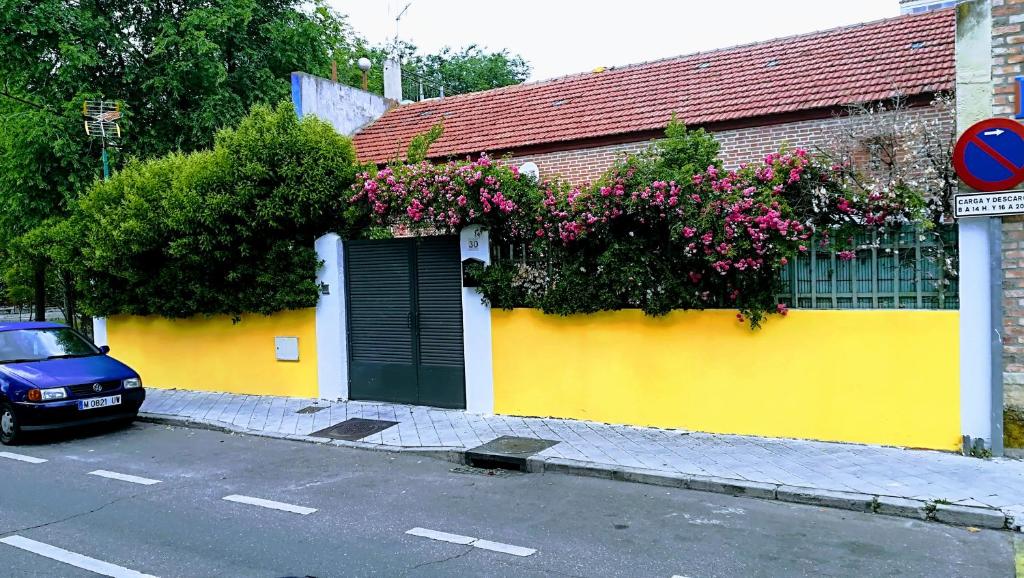 a yellow building with flowers on the side of it at Villa "Luna de Segovia" in Leganés