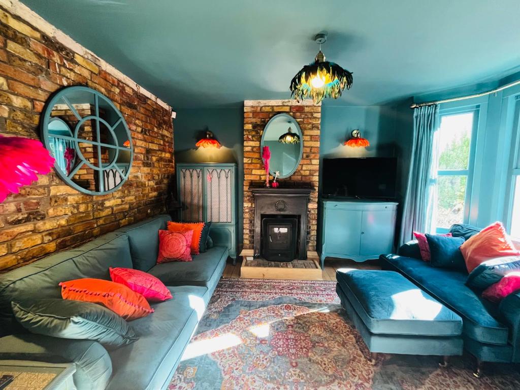 a living room with a couch and a fireplace at Harbour Cottage in Folkestone