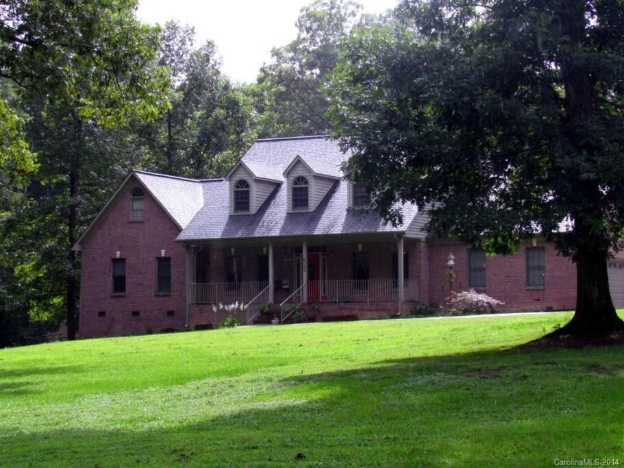 a red brick house with a tree in the yard at Quiet property on 3 acres yet close to city life 