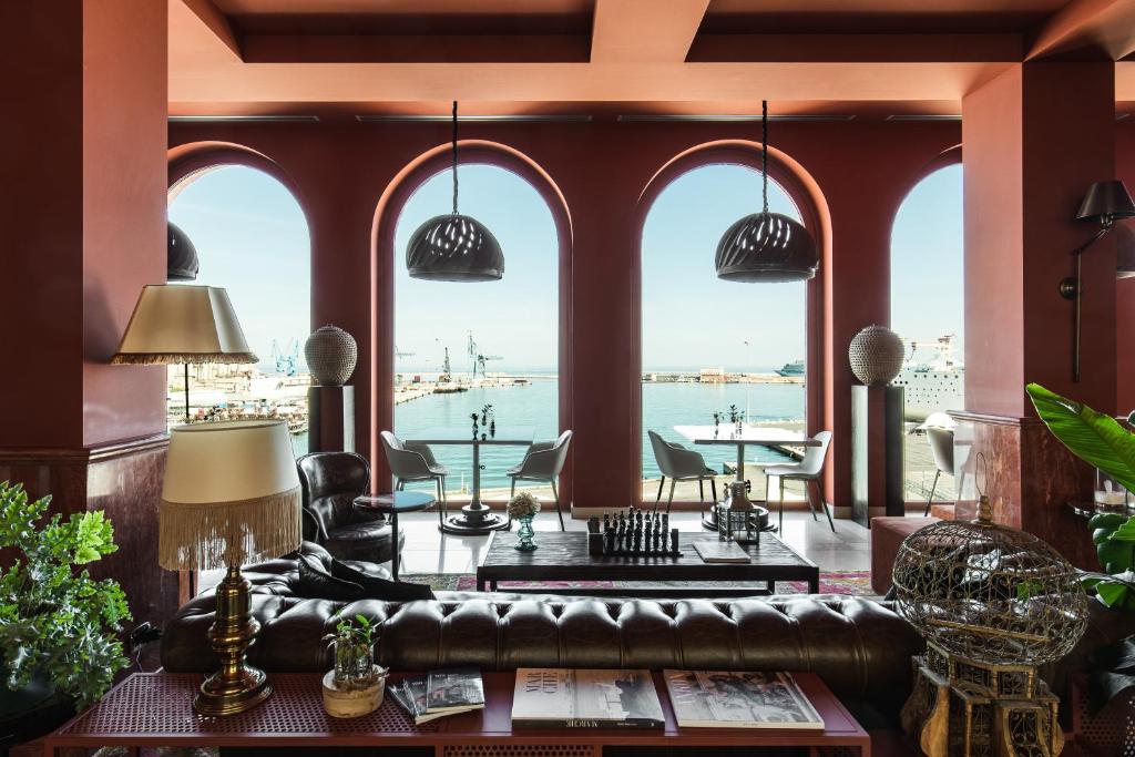 a living room with arched windows and a leather couch at SeePort Hotel in Ancona