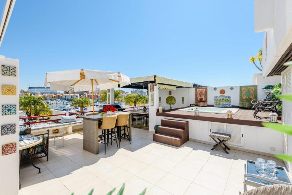an outdoor patio with a bar and a table at Marina Real - Sea View by HD PROPERTIES in Vilamoura
