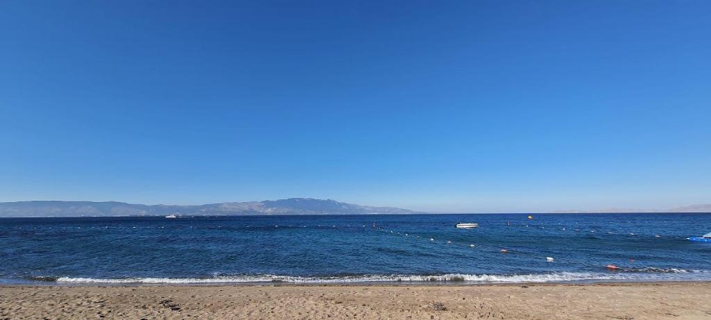 a beach with a body of water with a boat at CHARM BEACH HOTEL in Akyarlar