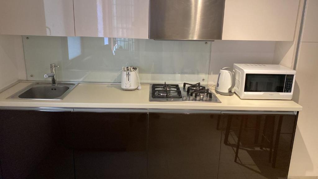a kitchen counter with a sink and a microwave at BIENNALE APARTMENT NEAR SAN MARCO in Venice