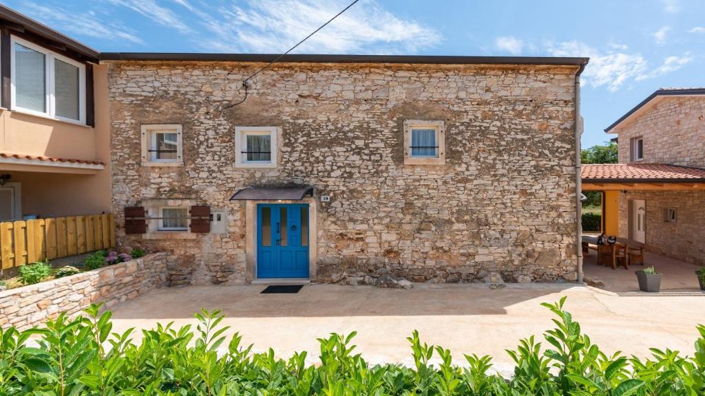 ein Steinhaus mit blauer Tür in der Unterkunft Holiday Home Lino in Dajla