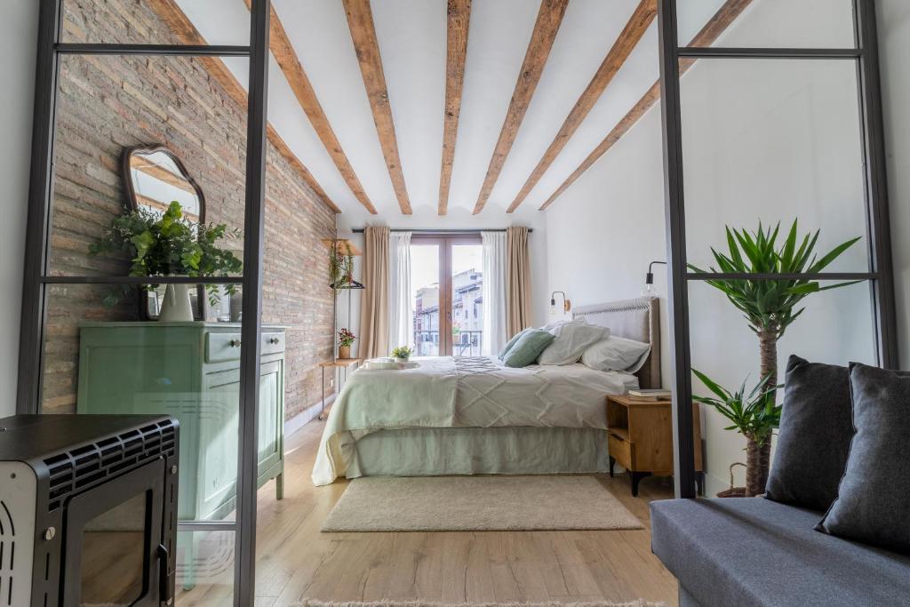 a bedroom with a bed and a brick wall at Cathedral Suite Home in Logroño