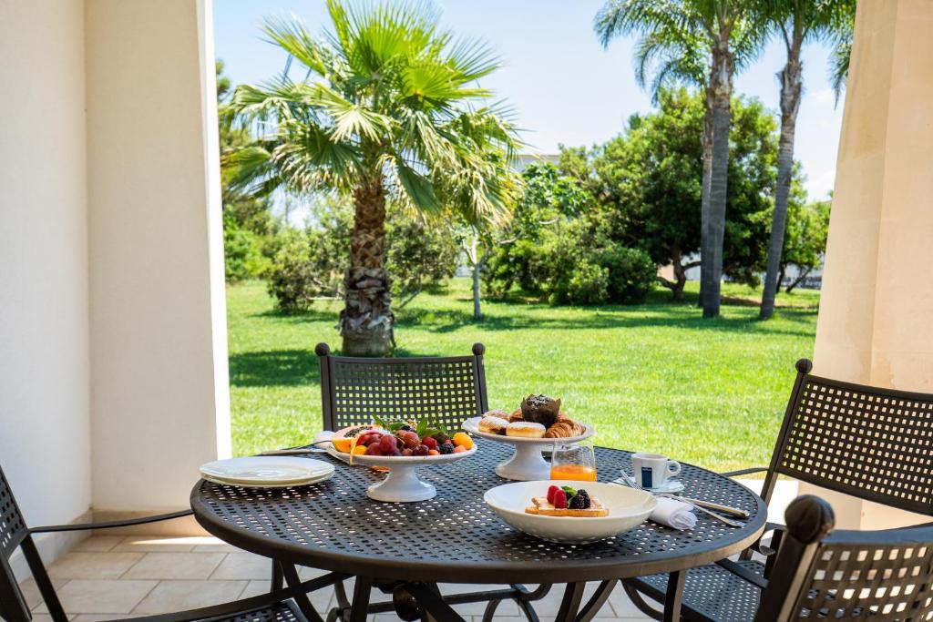 un tavolo con due ciotole di frutta su un patio di Giardino Dei Pini - Boutique Hotel ad Alliste