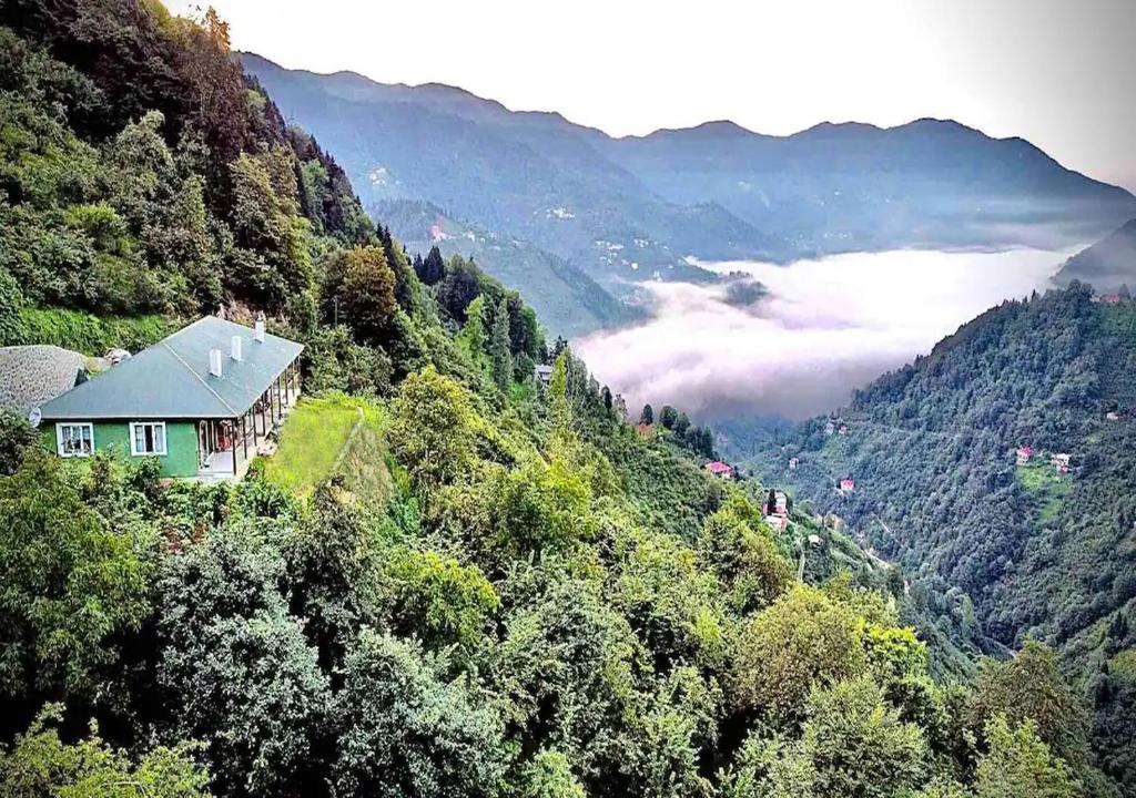 une maison sur le flanc d'une montagne avec une vallée dans l'établissement Trabzon Mountain House-UZUNLU, à Trabzon