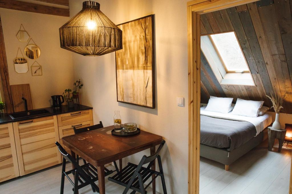 a bedroom with a bed and a table and a kitchen at Daj Spokój w Szczyrku in Szczyrk