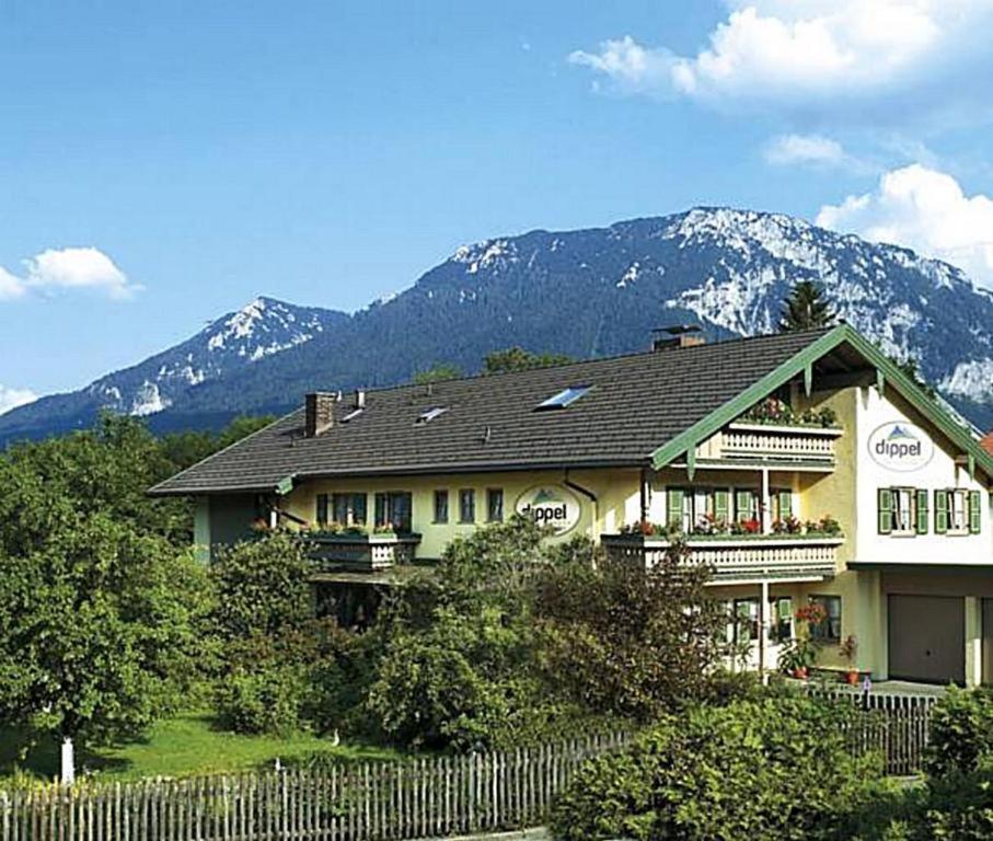 a house with a fence in front of a mountain at Haus Dippel in Ruhpolding