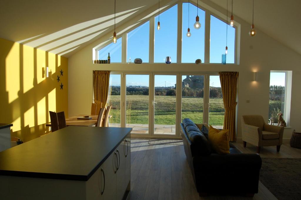eine Küche und ein Wohnzimmer mit einem großen Fenster in der Unterkunft Beautiful, Modern Villa 5 mins walk from the Stunning Bay at Trearddur in Holyhead