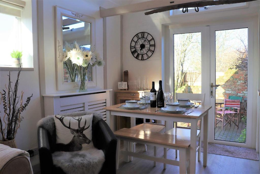 ein Wohnzimmer mit einem Tisch, einem Stuhl, einem Tisch und einem Esszimmer in der Unterkunft Beautiful Barn Conversion, 3 Bed, hot tub, sauna, gym, enclosed garden in Ryde