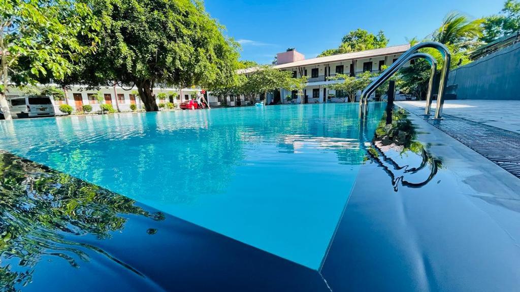 a large swimming pool with blue water at UD Garden Hotel in Kataragama