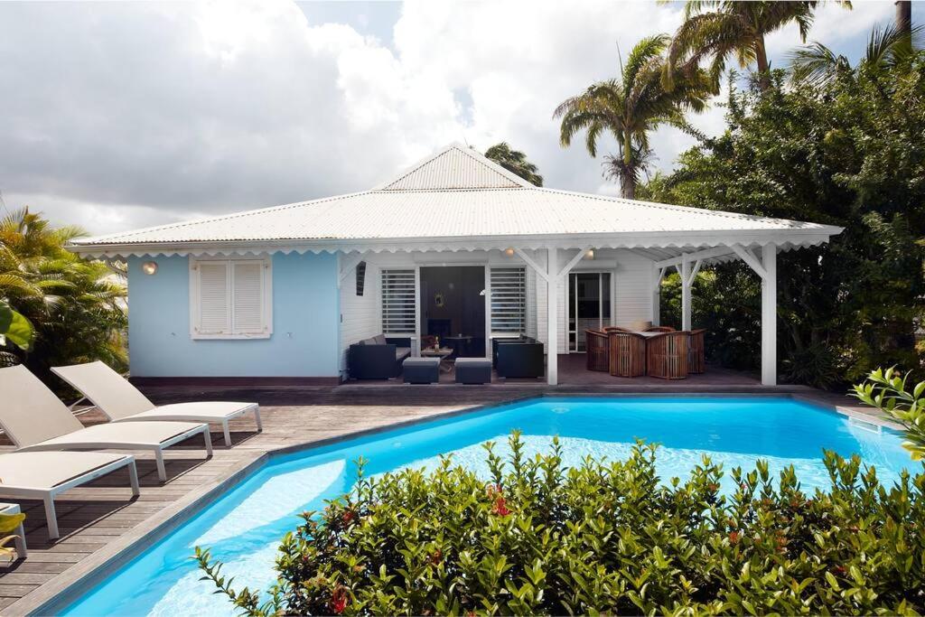 a villa with a swimming pool and a house at Villa Gauguin in Sainte-Rose