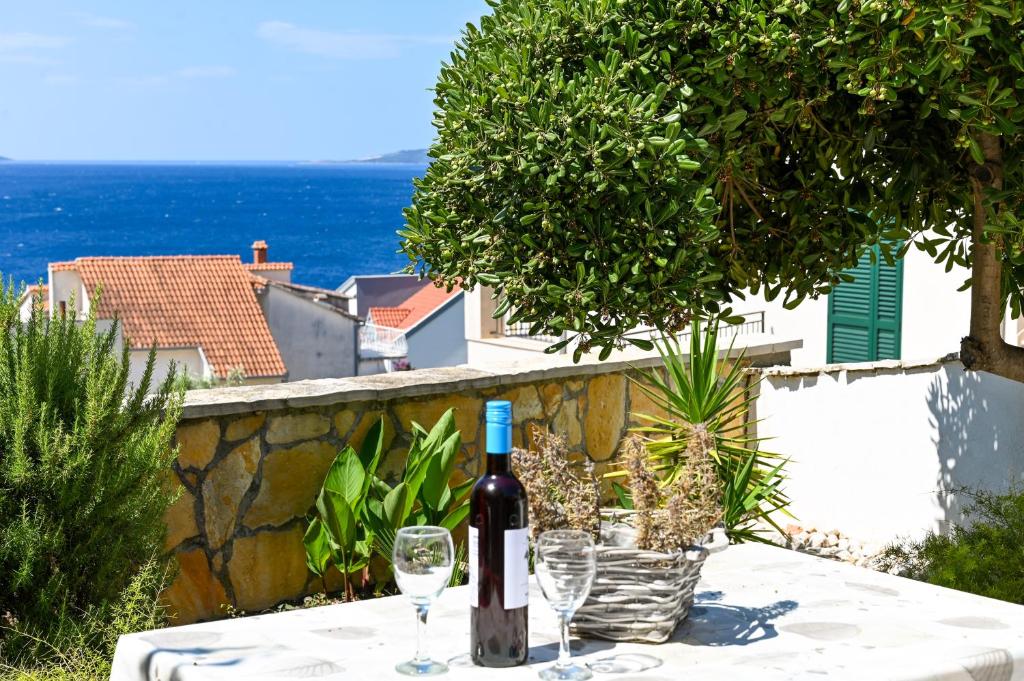 eine Flasche Wein auf einem Tisch mit Brille in der Unterkunft Villa Grande Vista - Lovely Apartment with Private spacious lush mediterranean patio and Sea view in Trogir