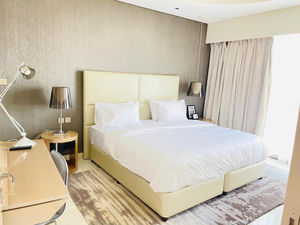 a bedroom with a large white bed and a desk at D3001 Paramount hotel residence 5 star luxury 2bedroom close to Burj Khalifa and Dubai mall in Dubai