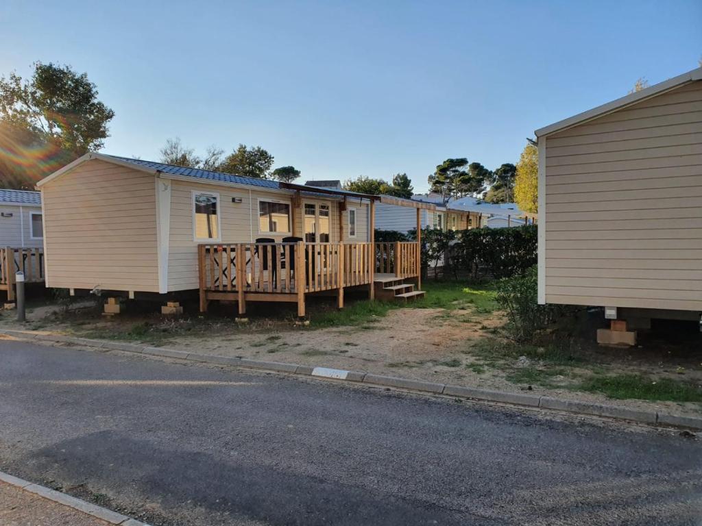 a row of mobile homes on the side of a street at Mobil home - Clim, TV - Camping '4 étoiles' - Narbonne Plage - 014 in Narbonne-Plage