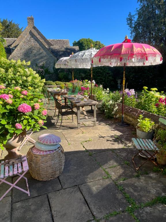 a patio with a picnic table and an umbrella at Pytts House Boutique Bed & Breakfast in Burford