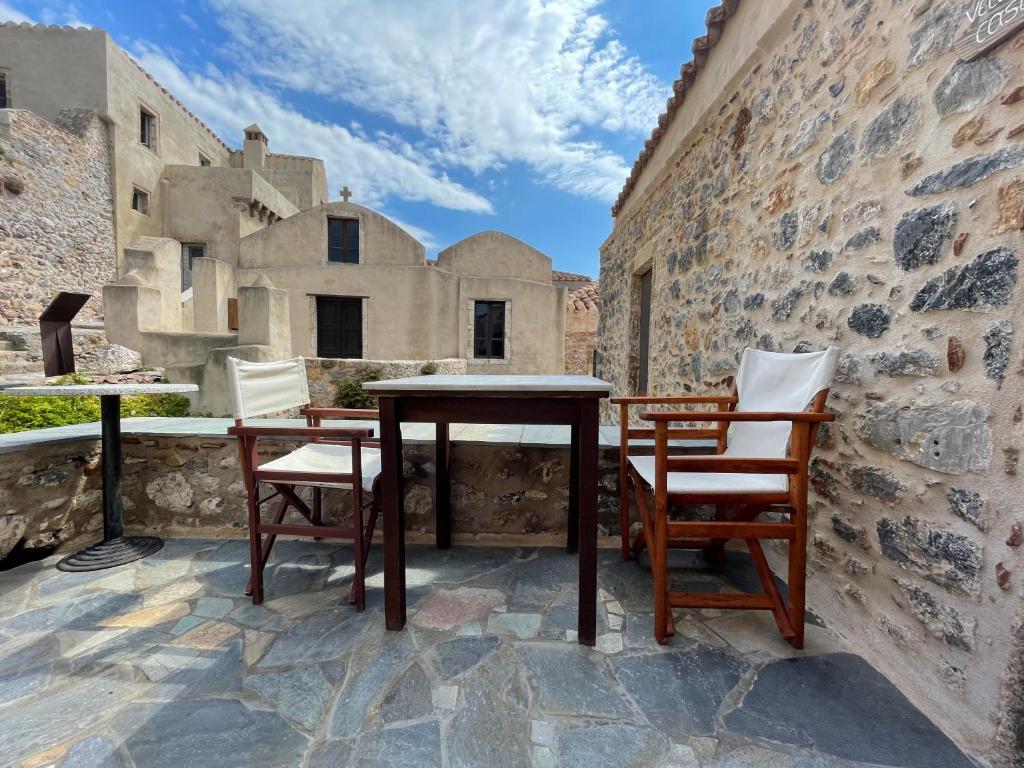- une table et deux chaises sur une terrasse en pierre dans l'établissement vecchia casa, à Monemvasia