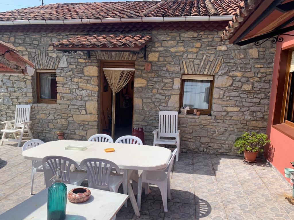 a patio with a table and chairs and a building at Casa Rural La Sosiega con jardín privado in Bernueces