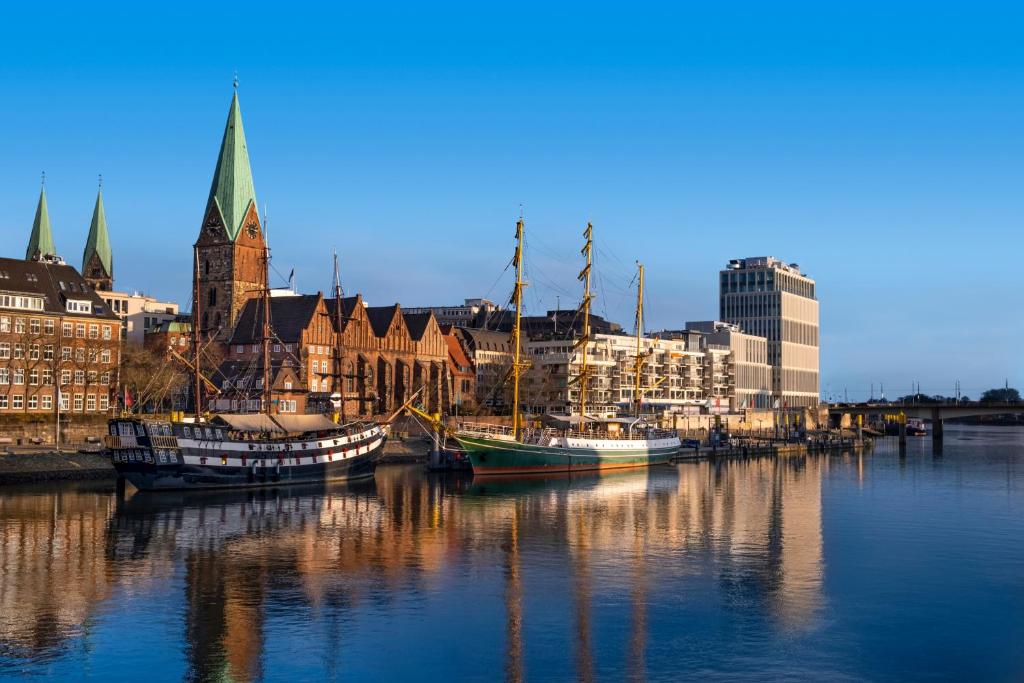 eine Gruppe von Booten, die in einem Hafen mit Gebäuden angedockt sind in der Unterkunft Vienna House Easy by Wyndham Bremen in Bremen