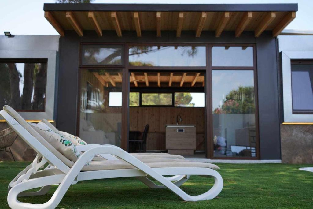 una silla blanca sentada en el césped frente a una casa en Novoecosuites descansa en el lugar de tus sueños, en Chiclana de la Frontera