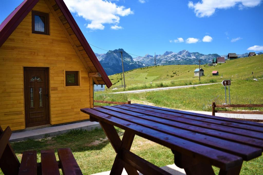 a wooden picnic table in front of a cabin at Durmitor view in Žabljak