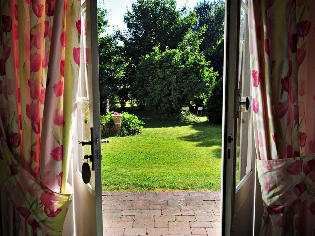 an open door with a view of a yard at Petit Garros in Fronsac