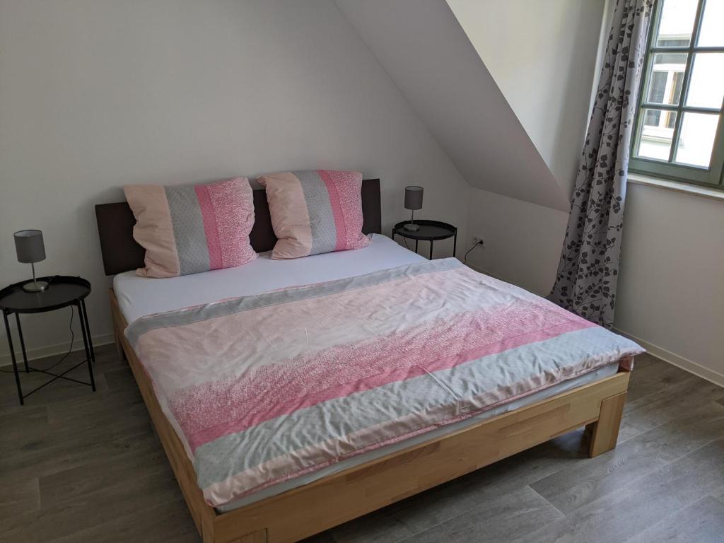 a bedroom with a bed with two tables and two windows at Gut schlafen in der Innenstadt von Zittau - Ferienwohnungen IO19 in Zittau