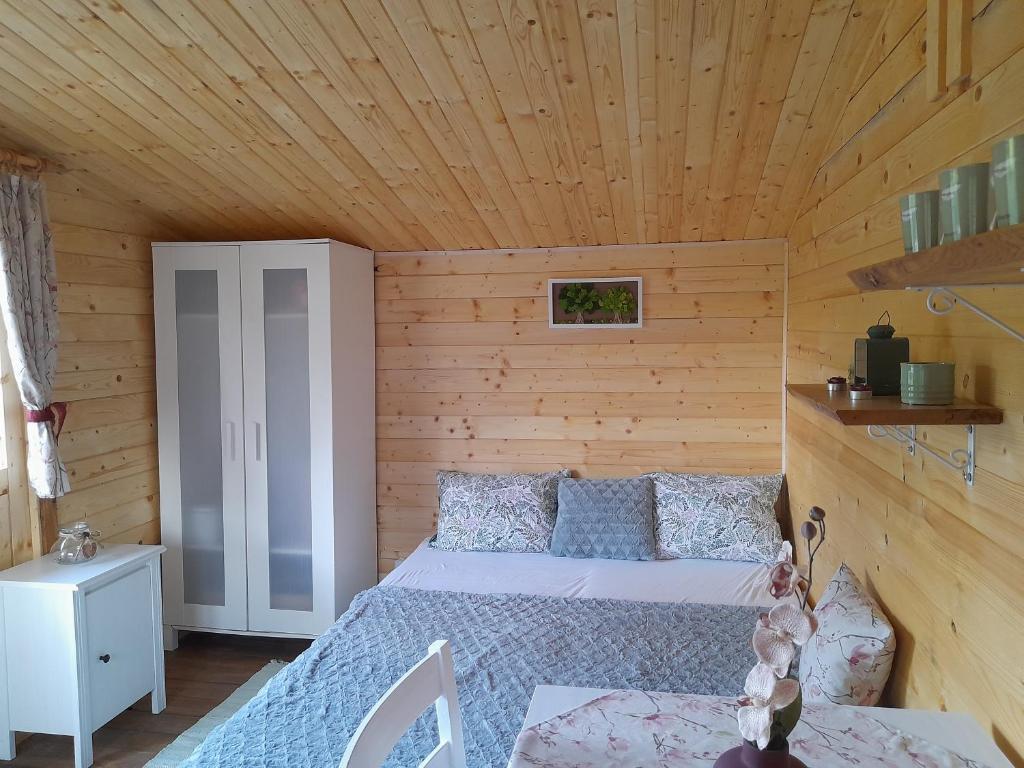a bedroom with a bed in a wooden cabin at Chatka Katka ubytovanie Teplý Vrch in Budikovany