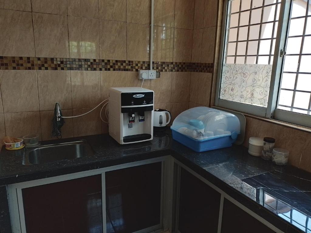 a kitchen with a sink and a coffee maker on a counter at Rahman Homestay Pantai Johor - ISLAM SAHAJA in Alor Setar