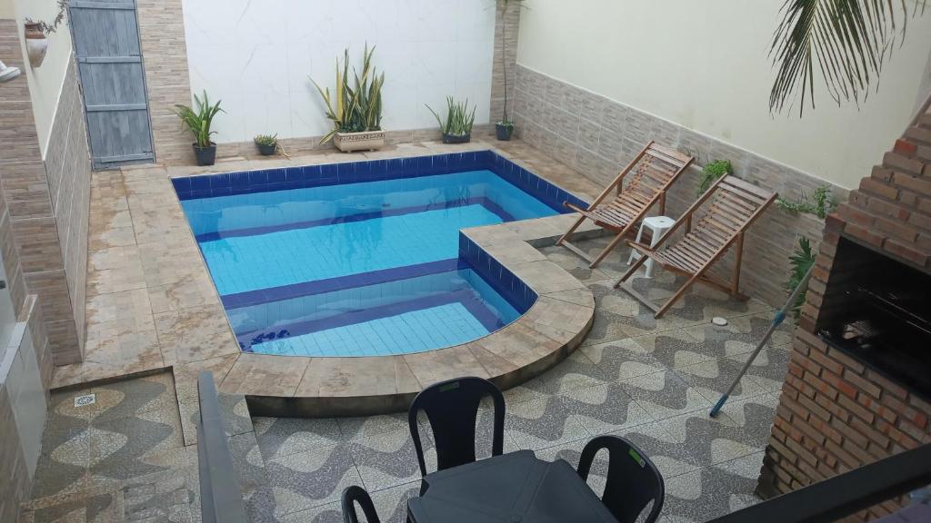 a swimming pool with two chairs and a table at Casa Larithur in Beberibe