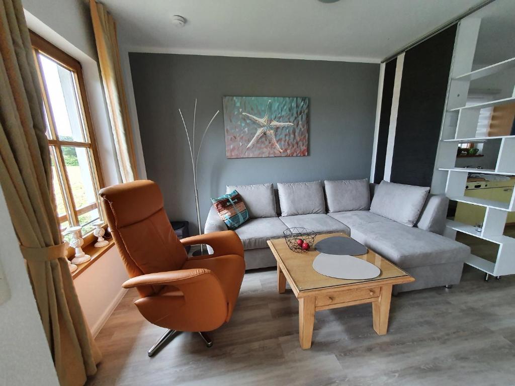 ein Wohnzimmer mit einem Sofa und einem Tisch in der Unterkunft Ferienwohnung Am Golfplatz 18 in Wittenbeck