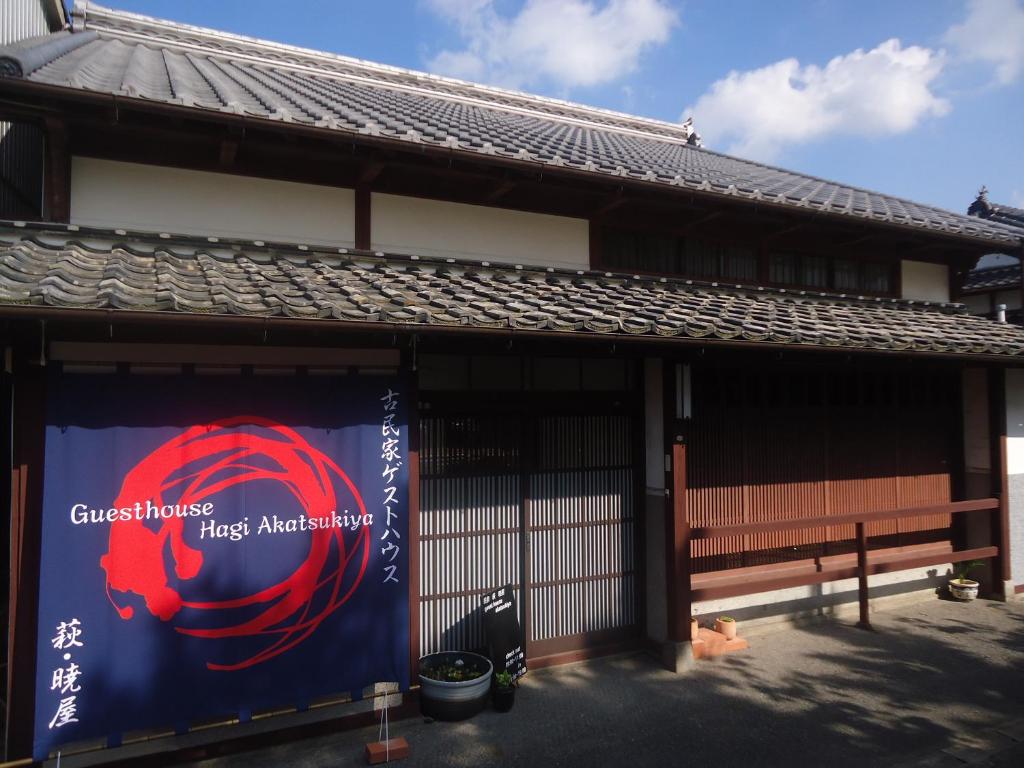 a building with a sign on the side of it at Kominka Guesthouse Hagi Akatsukiya in Hagi