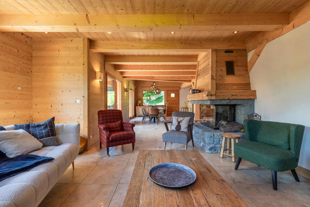 a living room with a couch and a fireplace at Chalet Les Bognettes 10 personnes in Le Grand-Bornand