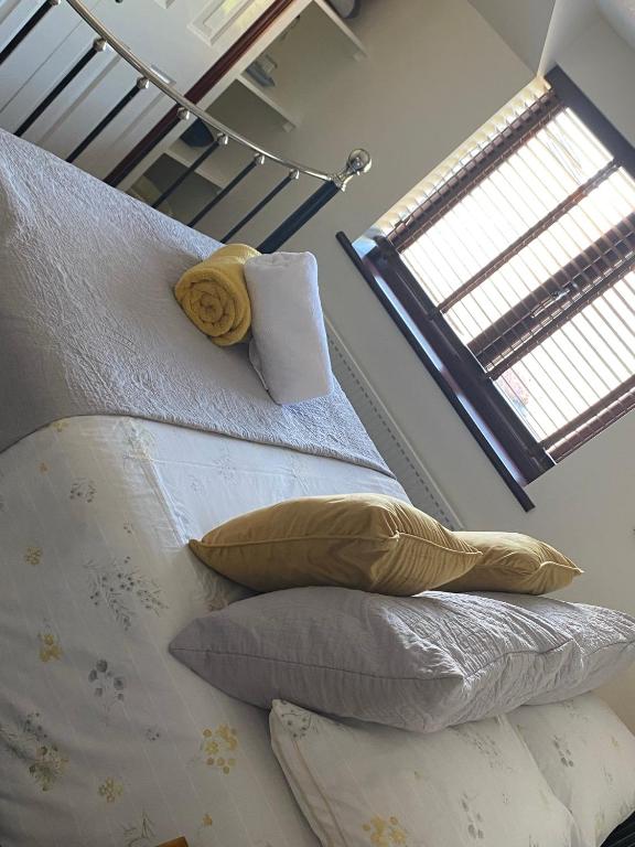 a bedroom with two beds with pillows and a window at Meadowview Cottage, Garden View in Camborne