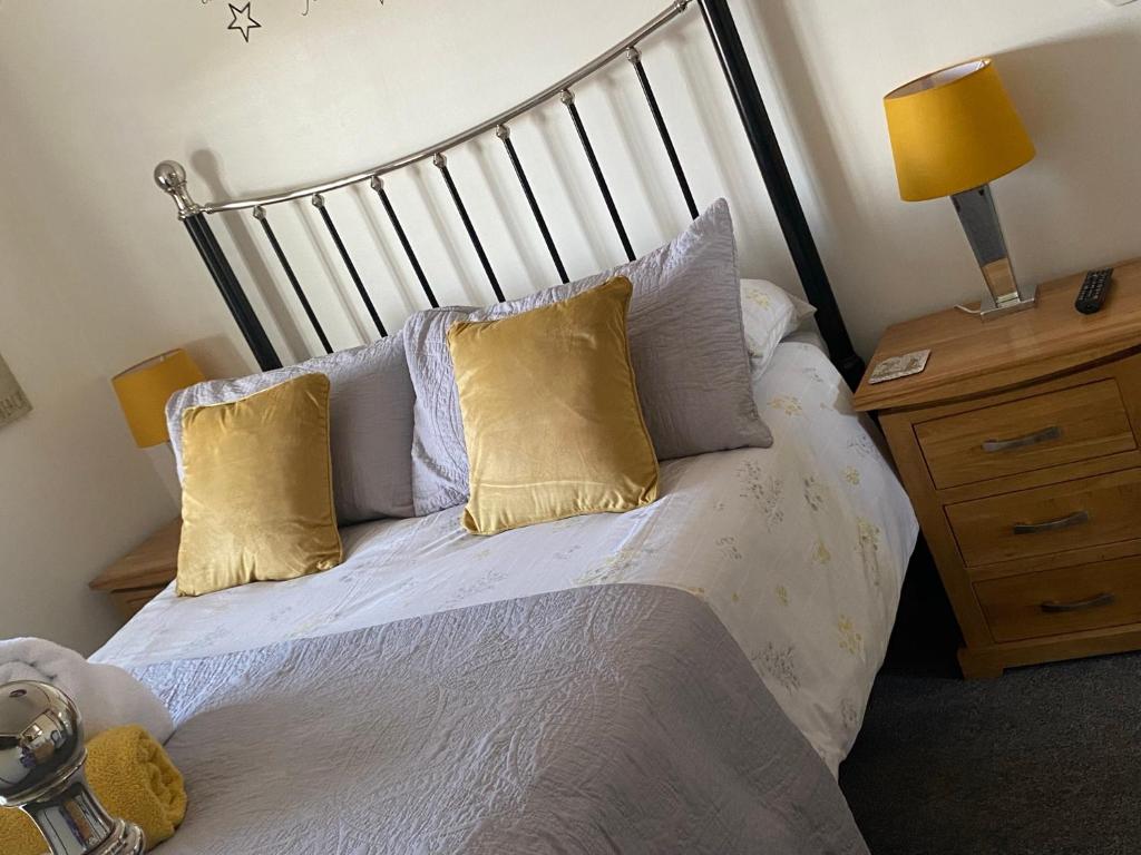 a bed with two pillows on it in a bedroom at Meadowview Cottage, Garden View in Camborne