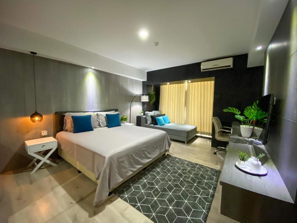 een slaapkamer met een bed, een bank en een tafel bij Lavenderbnb Room 8 at Mataram City in Yogyakarta