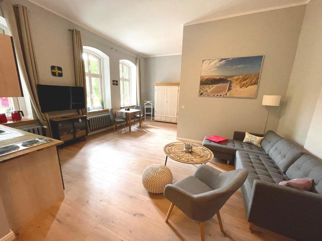 uma sala de estar com um sofá e uma mesa em Gästehaus Sternschanze - App1 Admiral em Stralsund