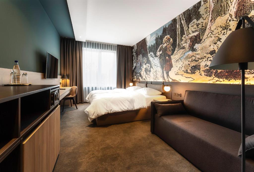 una camera d'albergo con letto e divano di Hotel Viktorosa a Hofgeismar
