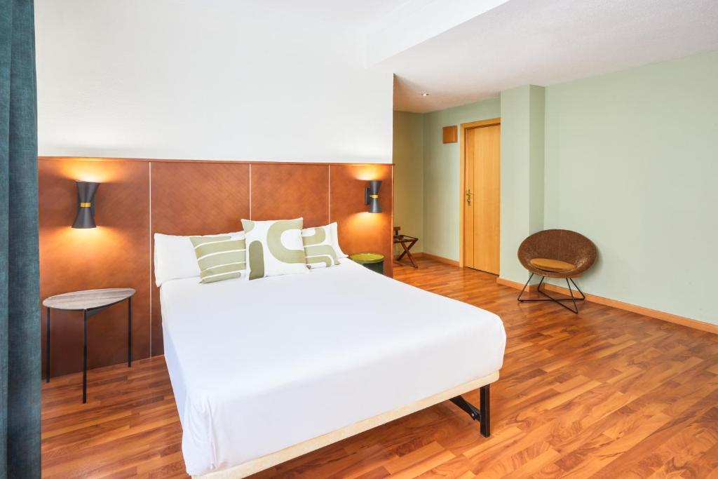 - une chambre avec un grand lit blanc et du parquet dans l'établissement Hôtel Casón del Tormes by HappyCulture, à Madrid