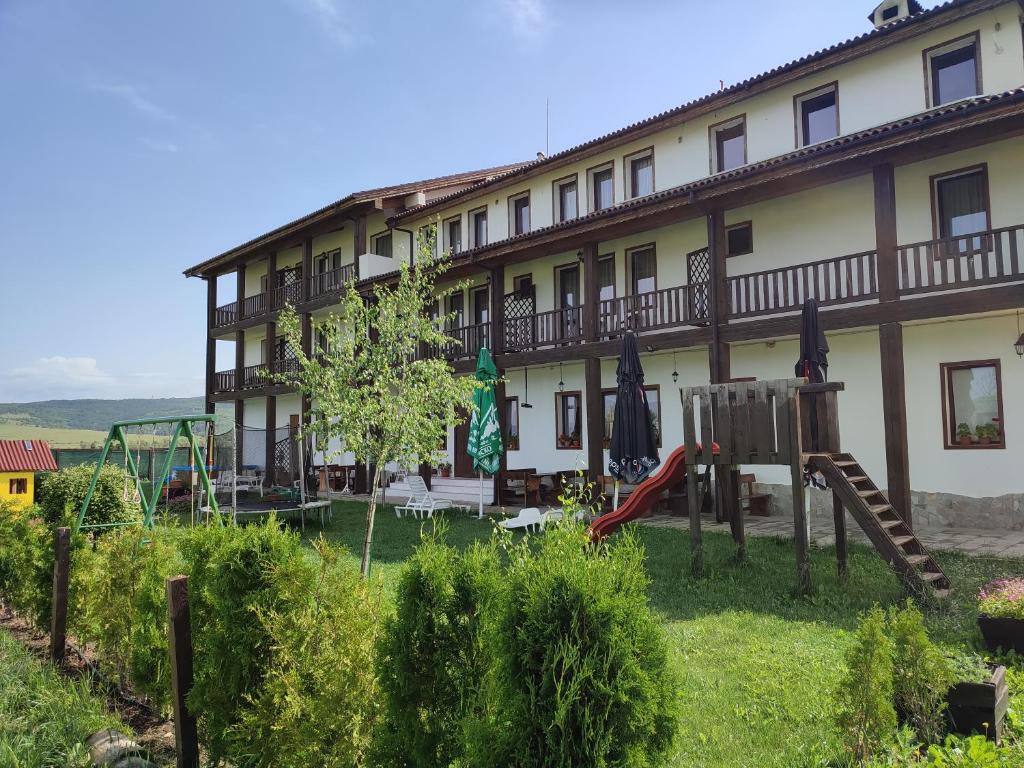 a hotel with a playground in front of a building at Guest House Belchin View in Belchin