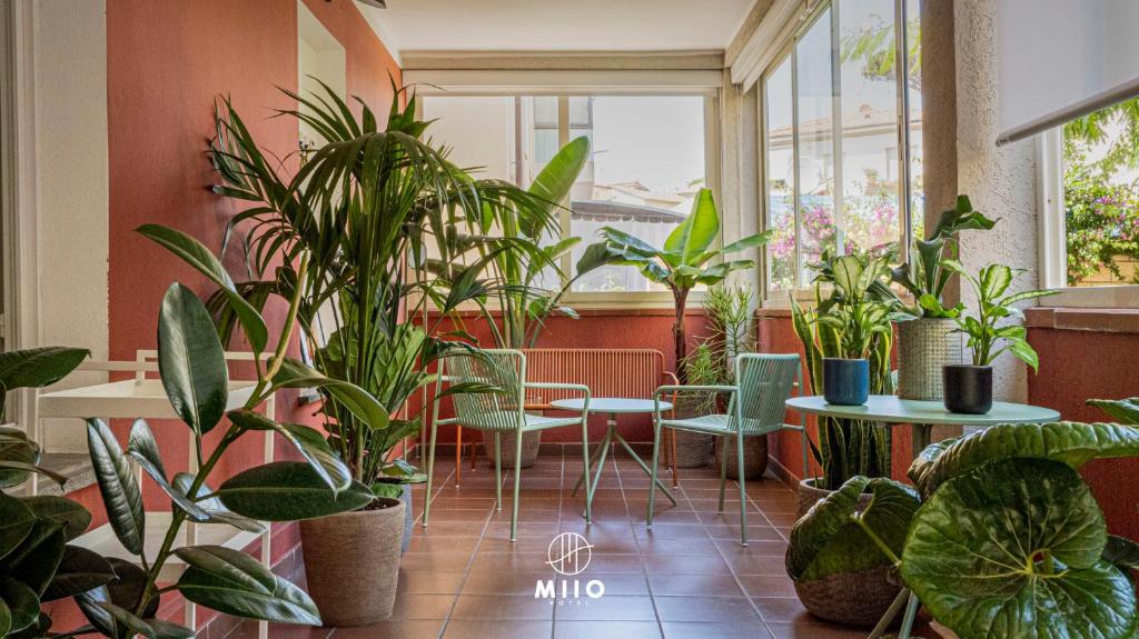 a room filled with lots of plants and tables and chairs at MIIO HOTEL in San Vincenzo