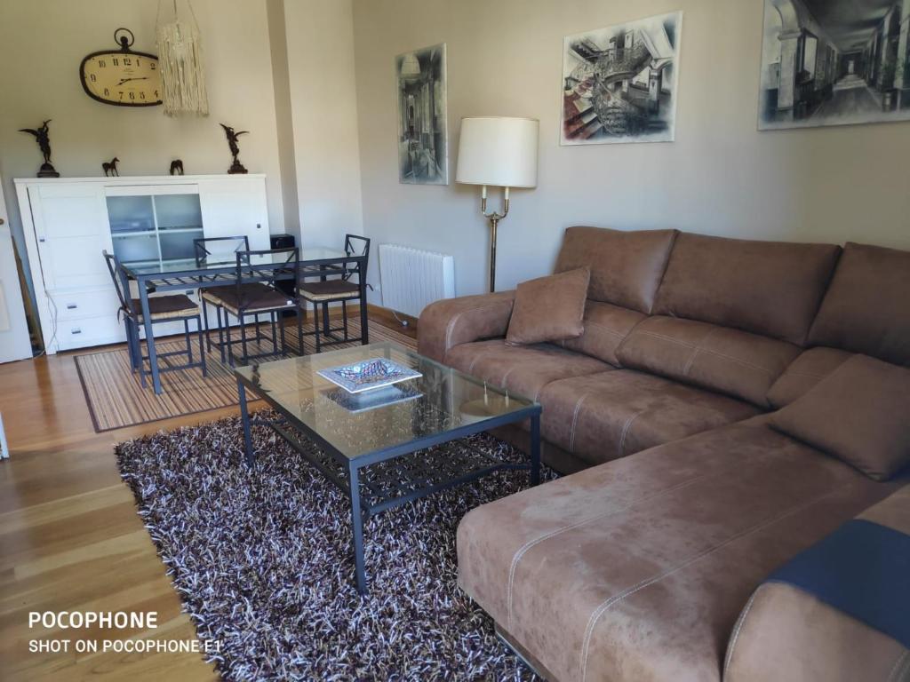 ein Wohnzimmer mit einem Sofa und einem Tisch in der Unterkunft Edificio histórico Mondariz-Balneario, tranquilidad, ideal para el teletrabajo in Mondariz-Balneario